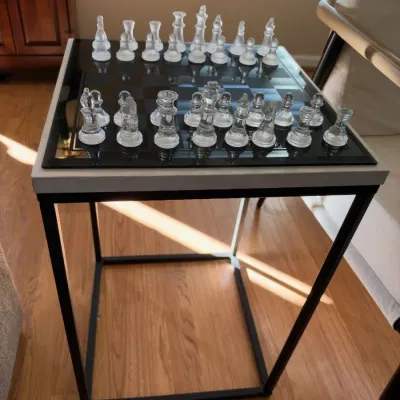 Glass chess set on black metal side table