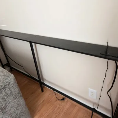 Narrow black metal behind-sofa console table with outlets