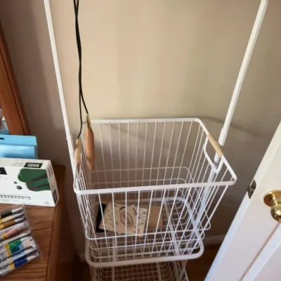 White metal rolling laundry cart with wire baskets