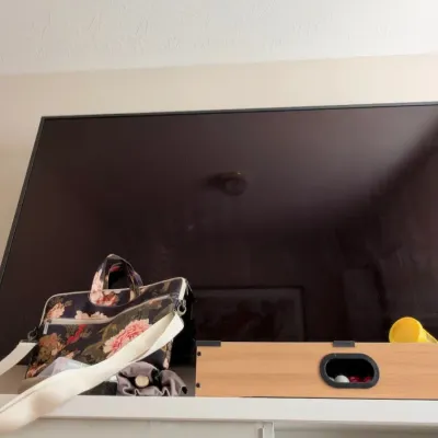 Flat screen TV and floral tote bag