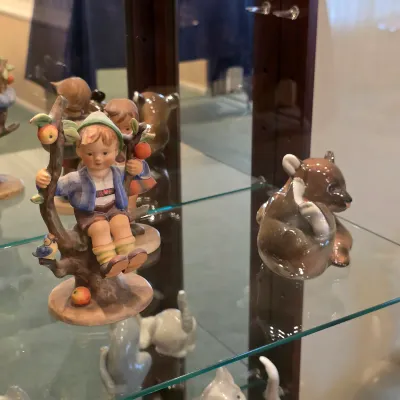 Genuine Hummel child figurine with a fruit-laden tree, displayed beside a small animal figure.