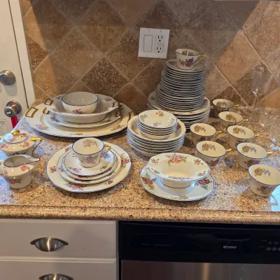 Haviland Limoges floral china with blue edging and gold handles, including dinnerware and serving pieces.