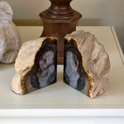 Pair of polished geode bookends with natural stone exteriors and contrasting banded interiors.