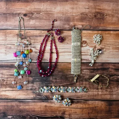 Vintage costume jewelry assortment featuring colorful necklaces, rhinestone bracelets and brooches.