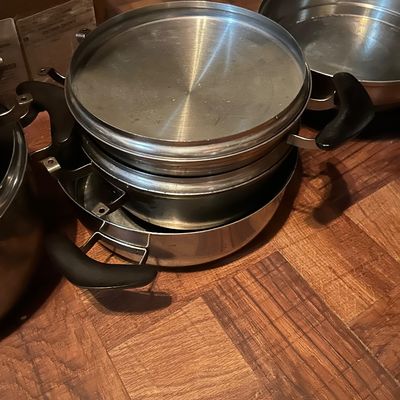 Sale Photo Thumbnail #50: Vintage stainless steel multi-tier steamer pot set with black handles, showing some wear from use.