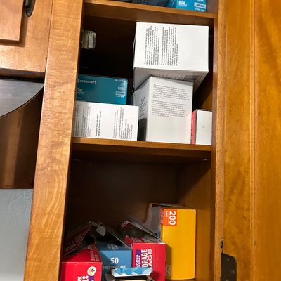 Sale Photo Thumbnail #15: Assorted household supplies including LED light bulbs, storage bags, and toothpicks stored inside a wooden kitchen cabinet.