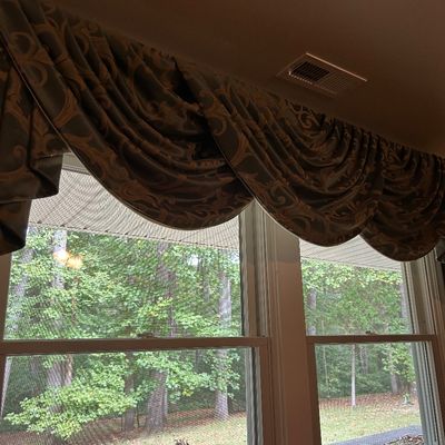 Sale Photo Thumbnail #19: Traditional swag valance curtain featuring a brown and gold damask pattern, draped over a double window.
