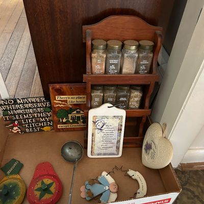 Sale Photo Thumbnail #126: Vintage wooden spice rack with glass spice jars, accompanied by various country-style kitchen decor items, signs, and a metal ladle.