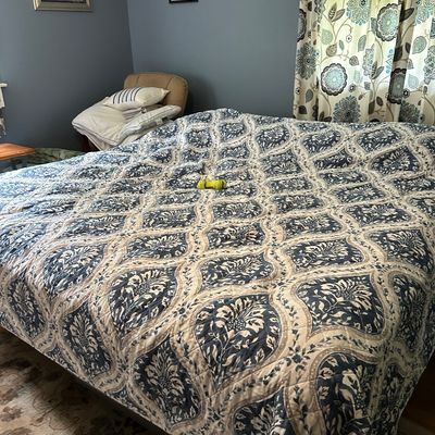 Sale Photo Thumbnail #104: Quilted bedspread featuring a blue and cream damask-style ogee pattern, shown on a bed in a bedroom setting.