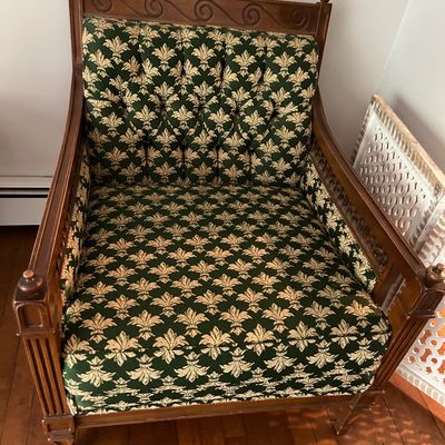 Sale Photo Thumbnail #144: Vintage wooden armchair featuring a tufted backrest and green upholstery with a gold fleur-de-lis pattern.