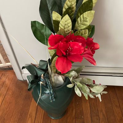 Sale Photo Thumbnail #143: Festive artificial floral arrangement featuring red amaryllis, green foliage, and a dark green ceramic vase.