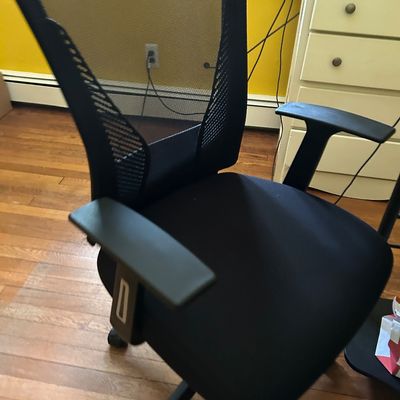 Sale Photo Thumbnail #111: Modern black mesh office chair with adjustable armrests and a padded seat, shown in good used condition.