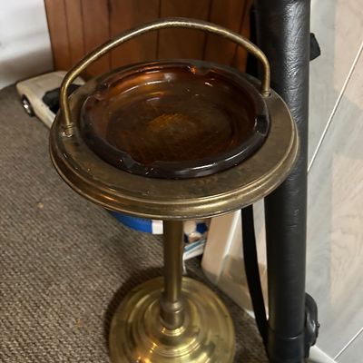 Sale Photo Thumbnail #55: Vintage mid-century brass floor-standing ashtray featuring a carrying handle and a removable amber glass insert.