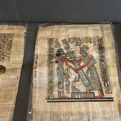 Sale Photo Thumbnail #123: Hand-painted Egyptian papyrus art depicting a pharaoh and deity, preserved in a protective plastic sleeve.