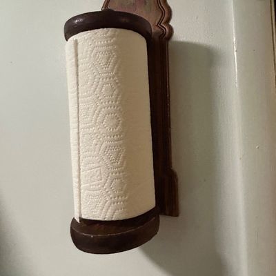 Sale Photo Thumbnail #30: Vintage wall-mounted wooden paper towel holder with a decorative shaped backplate and dark finish.