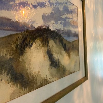 Sale Photo Thumbnail #127: Framed watercolor painting depicting a grassy dune landscape under a cloudy sky, presented in a simple wooden frame with a white mat.