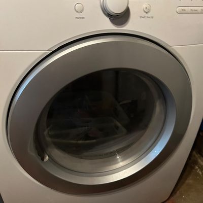 Sale Photo Thumbnail #61: Modern white front-loading clothes dryer with a silver-trimmed door and digital control panel.