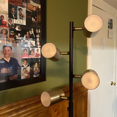 Sale Photo Thumbnail #89: Modern multi-light floor lamp featuring a black metal pole with four adjustable cylindrical brass shades.