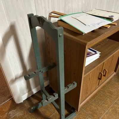 Sale Photo Thumbnail #80: Vintage green-painted wooden gun rack standing next to a laminate wood-grain media cabinet with lower doors.