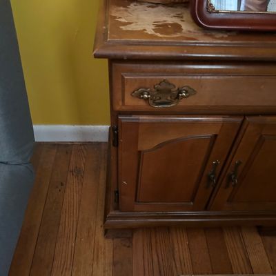 Sale Photo Thumbnail #119: Vintage wooden nightstand or small cabinet with a single drawer and double doors, showing significant wear and finish loss on the top surface.