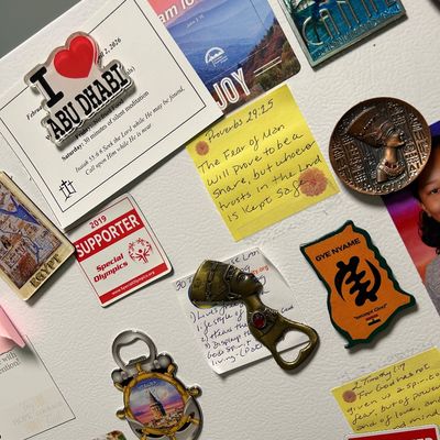Sale Photo Thumbnail #10: Assorted collection of souvenir refrigerator magnets, including travel-themed magnets from Abu Dhabi, Egypt, and Istanbul, alongside religious and charitable support magnets.