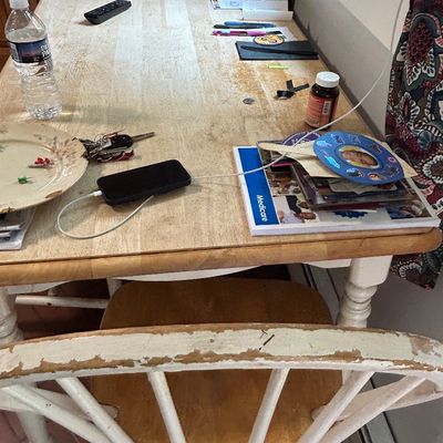Sale Photo Thumbnail #45: Light wood dining table with turned legs, paired with two white-painted wooden Windsor-style chairs showing significant paint wear.