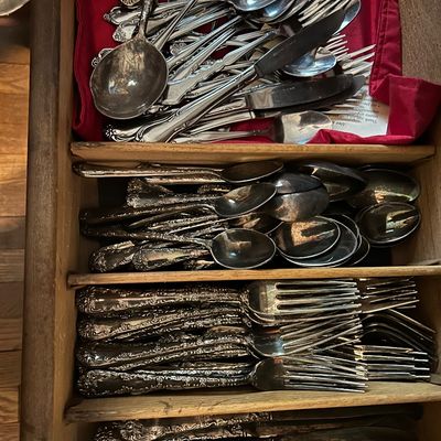 Sale Photo Thumbnail #154: Vintage silver-plated flatware set with ornate floral handles, organized in a wooden drawer insert.