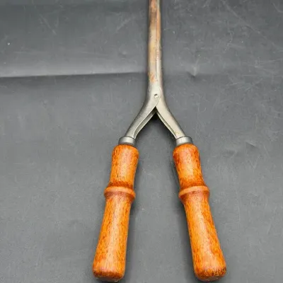 antique, stove-heated metal hair curling iron
