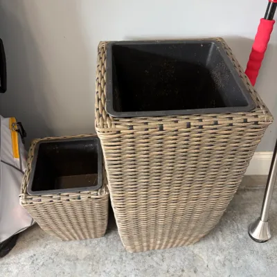 Sale Photo Thumbnail #180: Pair of modern woven resin wicker planters in varying heights, featuring removable black plastic liners.