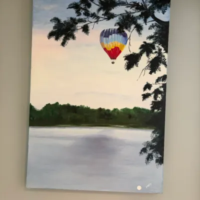 Sale Photo Thumbnail #32: Original acrylic painting on canvas depicting a colorful hot air balloon floating over a lake, signed "Nancy" in the bottom right corner.