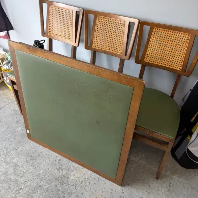 Sale Photo Thumbnail #76: Mid-century modern card table and chair set, featuring a square table with a green vinyl top and matching chairs with cane backs and green vinyl seats.
