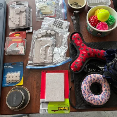 Sale Photo Thumbnail #137: Assortment of household utility items and pet supplies, including packages of felt furniture pads, furniture sliders, pet bowls, and plush dog toys.