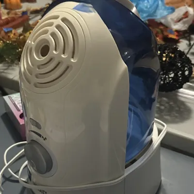 Sale Photo Thumbnail #20: HoMedics cool mist humidifier featuring a white and blue plastic body with adjustable mist control.