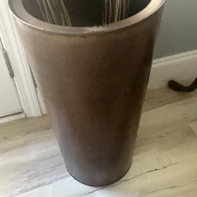 Sale Photo Thumbnail #62: Tall, cylindrical ceramic floor vase in a textured bronze or brown finish, holding decorative branches.
