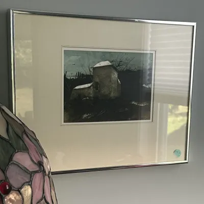 Sale Photo Thumbnail #24: Framed landscape print depicting a rustic stone building under a dark sky, matted and housed in a simple silver-tone metal frame.