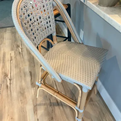 Sale Photo Thumbnail #90: French bistro-style counter stool featuring a natural rattan frame and light gray woven synthetic wicker seat and back.