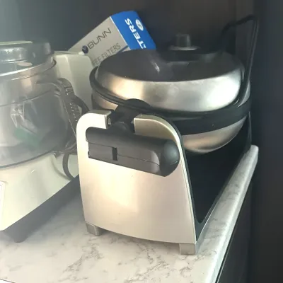 Sale Photo Thumbnail #16: Stainless steel rotating waffle maker alongside a small food processor and a box of Bunn coffee filters.