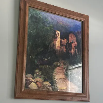 Sale Photo Thumbnail #23: Framed landscape print depicting a stone path leading toward a castle or monastery ruin, housed in a rustic brown wooden frame.