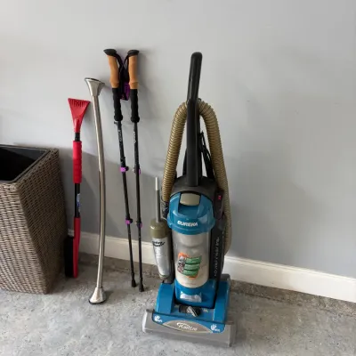 Sale Photo Thumbnail #155: Eureka PowerLine upright vacuum cleaner, a pair of trekking poles, a long metal shoehorn, and a red snow brush.