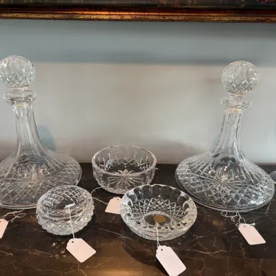 Sale Photo Thumbnail #52: Collection of elegant cut crystal glassware, including a pair of large decanters with stoppers and three small decorative bowls, all featuring intricate diamond-cut patterns.Waterford.