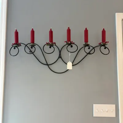 Sale Photo Thumbnail #67: Wrought iron wall-mounted candelabra with scrollwork design, holding six red ribbed candles accented with festive berry rings.