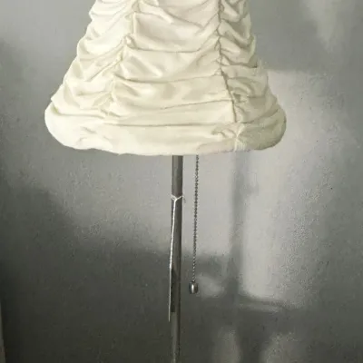Sale Photo Thumbnail #117: Vintage metal table lamp featuring a slender stem, ornate base, and a cream-colored ruched fabric shade.
