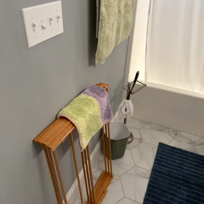 Sale Photo Thumbnail #159: Vintage-style wooden folding drying rack with a compact, collapsible design, shown in a bathroom setting.