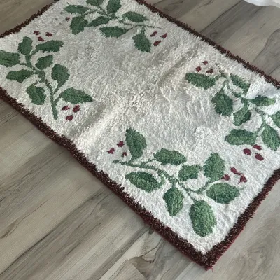 Sale Photo Thumbnail #187: Vintage holiday-themed bath mat or small accent rug featuring a holly and berry motif on a white background with a dark red border.