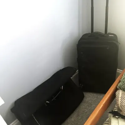 Sale Photo Thumbnail #141: Black rolling suitcase with extended handle alongside a matching black duffel bag, both in gently used condition.