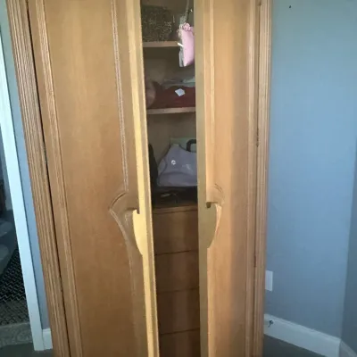 Sale Photo Thumbnail #77: Vintage light wood armoire featuring arched double doors, fluted side columns, and an interior with shelves and drawers.