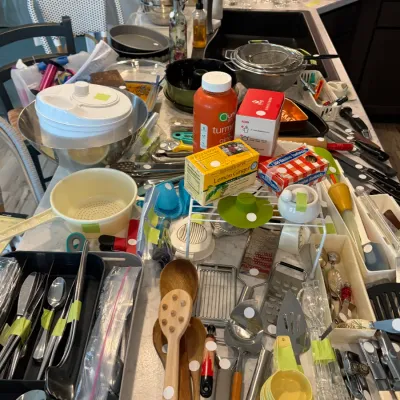 Sale Photo Thumbnail #111: Assorted kitchenware and utensils, including stainless steel bowls, wooden spoons, flatware, and small gadgets, displayed on a kitchen counter.