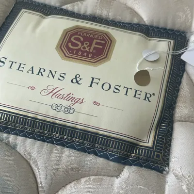 Sale Photo Thumbnail #75: Stearns & Foster Hastings mattress featuring a tufted, patterned cream fabric and the manufacturer's embroidered label.