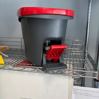 Sale Photo Thumbnail #152: Grey and red plastic spin mop bucket with a foot pedal mechanism, in clean condition.
