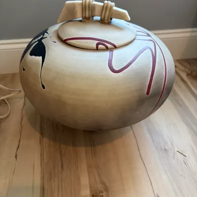 Sale Photo Thumbnail #66: Large contemporary studio pottery lidded jar with a matte beige finish, abstract black and maroon painted designs, and a unique sculptural handle.